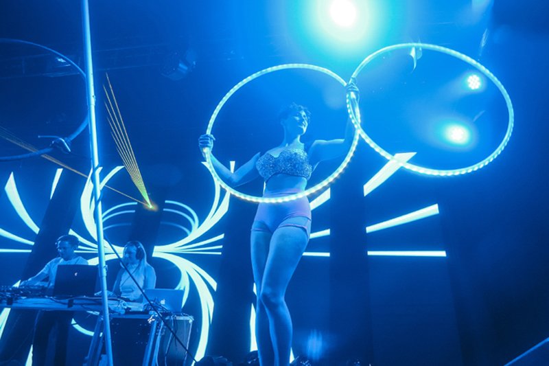 woman on stage holding LED hoola hoops