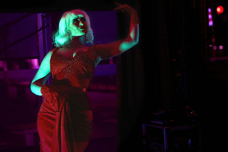 woman in red dress lit by stage lights